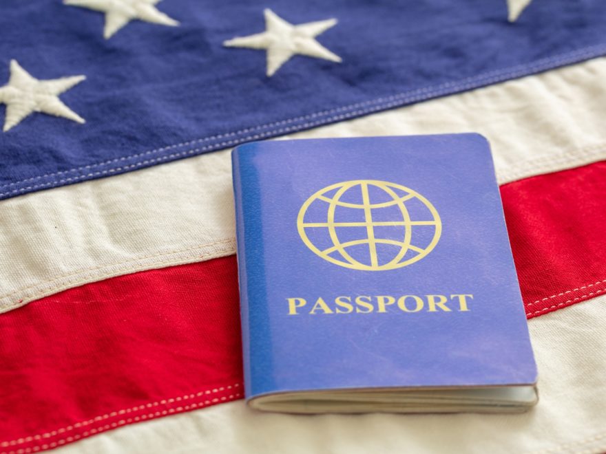 Blue passport on USA flag background, close up view.